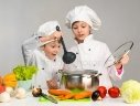 Приготовление маленький мальчик и девочка смотрит в сковороде — стоковое фото