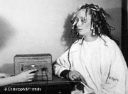 Eine Frau sitzt mit Wicklern im Haar vor einem Heizautomaten (Archivbild um 1930)