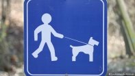 Ein Schild mit einem Mann, der einen Hund an der Leine führt