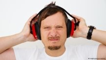 Ein Mann mit einem Lärmschutzkopfhörer verzieht das Gesicht