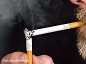 Ein Raucher zündet eine neue Zigarette an einer abgebrannten an