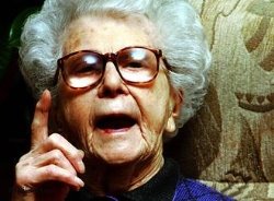 Eine alte Frau, die mit erhobenem Zeigefinger spricht