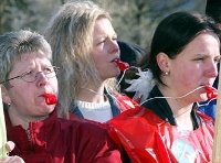 Drei Frauen mit Trillerpfeifen im Mund