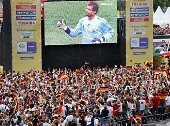 Eine Menschenmenge guckt auf einer Riesenleinwand ein Fußballspiel