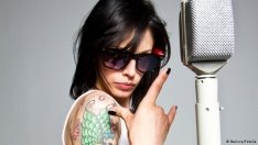 Eine Sängerin mit Tattoos und Sonnenbrille